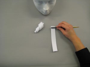 Paper stripes being rolled up to create curls